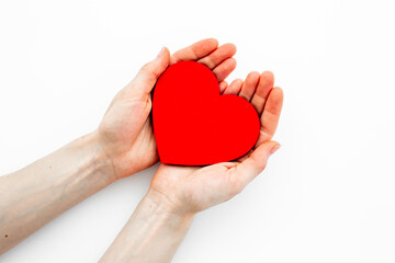 Obraz premium Red heart with woman hands, top view. Health care and love concept