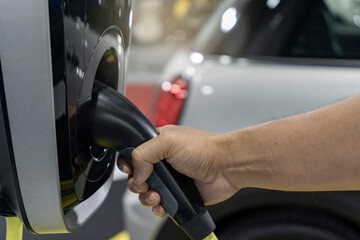 An electric car charging. Close up shot of electric car being charged at outdoor charging station....