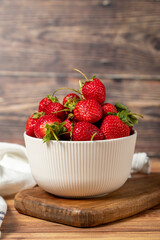 Strawberry in bowl. Organic farm products. Fresh strawberries on wooden background. Close up