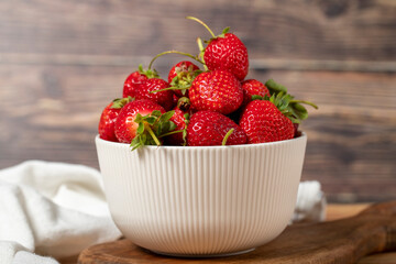Strawberry in bowl. Organic farm products. Fresh strawberries on wooden background. Close up