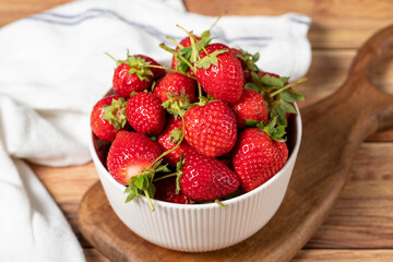 Strawberry in bowl. Organic farm products. Fresh strawberries on wooden background