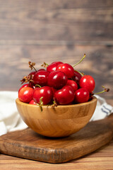 Cherry in bowl. Organic farm products. Fresh cherry on wooden background. Close up