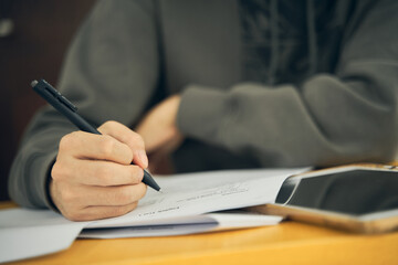 close up of a person holding a pen