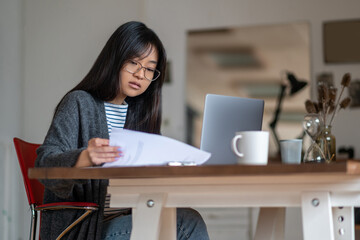 Long-haired asian young woman working in her home office
