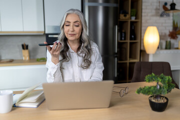 Long-haired beautiful business woman recording an audio message