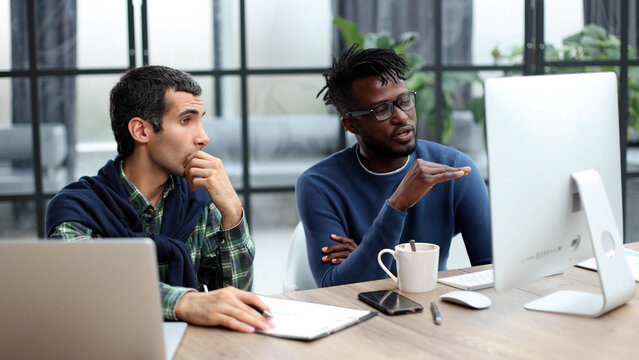 Business people working together in a modern trendy office behind a laptop