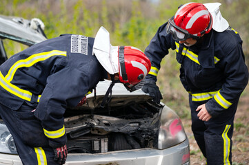 Fototapeta premium Car Crash Traffic Accident. Firefighters Rescue Injured Trapped Victims. Firemen give First Aid to passengers. High quality photography.