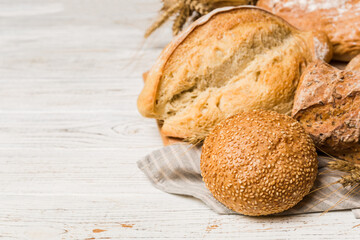 Homemade natural breads. Different kinds of fresh bread as background, perspective view with copy space