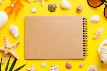 Blank writing book with summer beach accessories on background, copy space. Flat lay with copy space