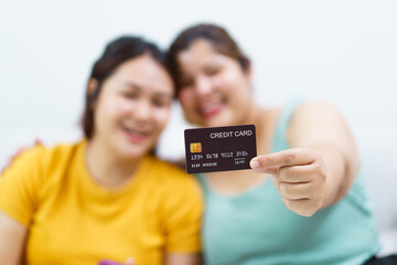 Two Asian fat women staying together and buying goods in e-commerce website.