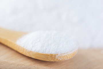 Fototapeta na wymiar Glucose or grape sugar in a spoon on a wooden board.