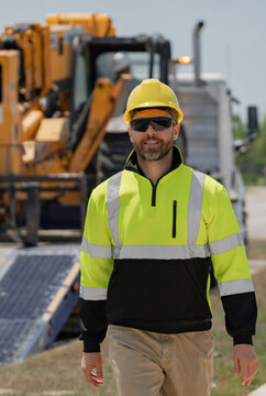 Machinery Builder At Buildings Background. Excavator Loader Tractor And Buider Worker. Portrait Of Worker Man Small Business Owner. Construction Worker With Hardhat Helmet On Construction Site.