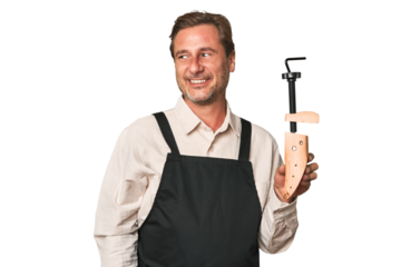 A middle-aged shoe maker looks aside smiling, cheerful and pleasant.