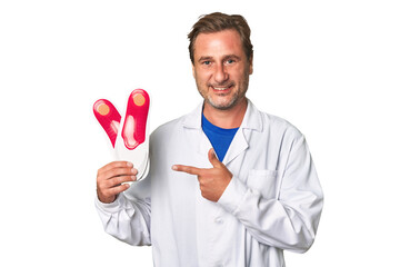 A middle-aged podiatrist holding an insoles