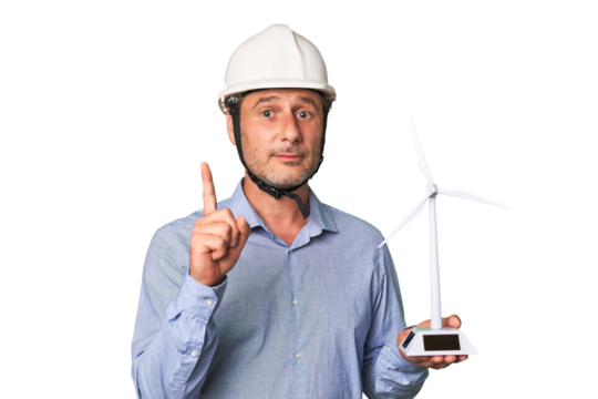 A middle-aged architect man holding a windmill model showing number one with finger.