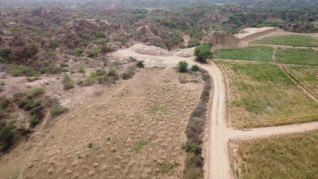 Drone flying over flat farmlands to reveal the unique gully erosion forming the iconic badlands of Chambal ravines in Morena plains on the Vindhyan Basin, India