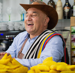 Colombian worker at the cafeteria bar with delicious empanadas