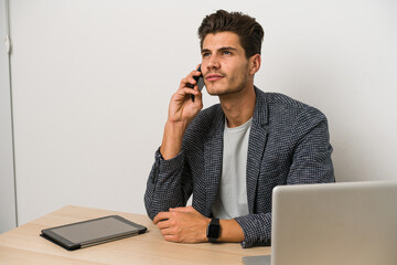 Young caucasian business entrepreneur man working with laptop, mobile phone and tablet