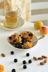 Muffins with apricots and black currants sprinkled with almond flakes