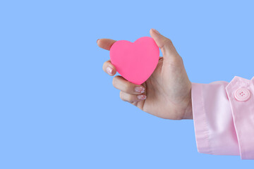 Obraz premium Heart in Doctor's hands on blue background. A Doctor's hand protecting and reassures patient.Healthcare and hospital medical. Organ donation,charity,cardiologist,heart care .Valentine day.copy space.