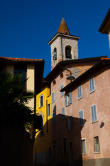 Fototapeta premium City Road with Old House and Church Tower in a Sunny Day in Arzo, Ticino, Switzerland.