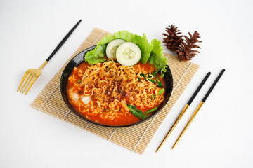 spicy ramen noodle soup with chopsticks on a white background