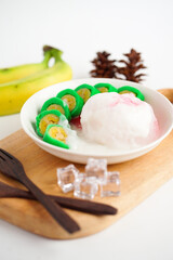 Es Pisang Ijo, traditional dessert from Makassar, South Sulawesi, Indonesia, made from banana which is rolled with a mixture of wheat flour, rice flour and coconut milk. Served with pureed and syrup