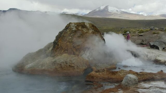 Young Woman Walking Around Steamy Rock at El Tatio Geyser, Atacama Desert, Chile.