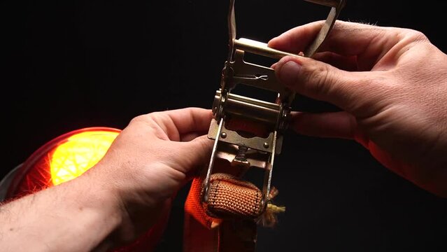 ratchet lashing straps orange operating principle in human hands 