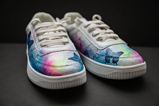 Closeup of customized trainer shoes on a gray surface