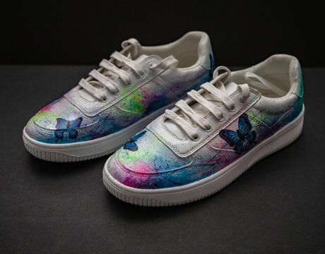 Closeup of customized trainer shoes on a gray surface