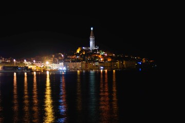 Fototapeta na wymiar Istria peninsula with Rovinj city lights reflecting on the surface of the sea in Croatia