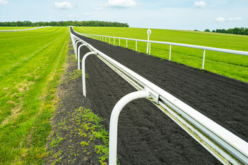 Shallow focus of the end of a lightweight plastic barrier seen at a racehorse training track in Newmarket, Suffolk, UK. - obrazy, fototapety, plakaty