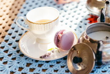 Cake macaron on the background of a cup of tea