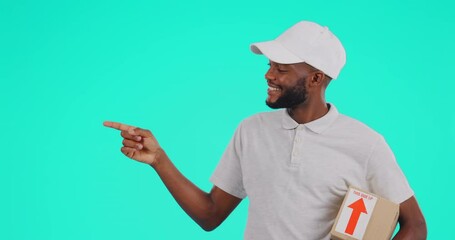 Portrait, delivery and point with a black man courier in studio on a blue background holding a box. Shipping, ecommerce and package with a happy male postal worker showing logo space for advertising