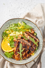 salad with grilled chicken, orange, cucumber and arugula