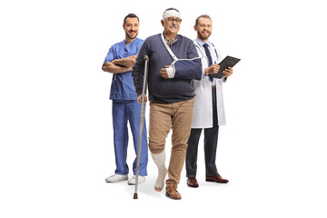 Male doctors and a mature male patient with leg and head injury