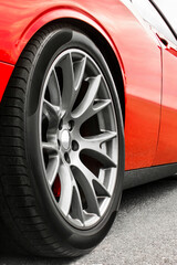 Red car. Car wheels close up on a background of asphalt. Car tires. Car wheel close-up. for advertising.