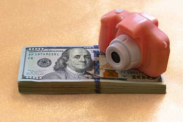 US 100 dollar banknotes and toy photo camera