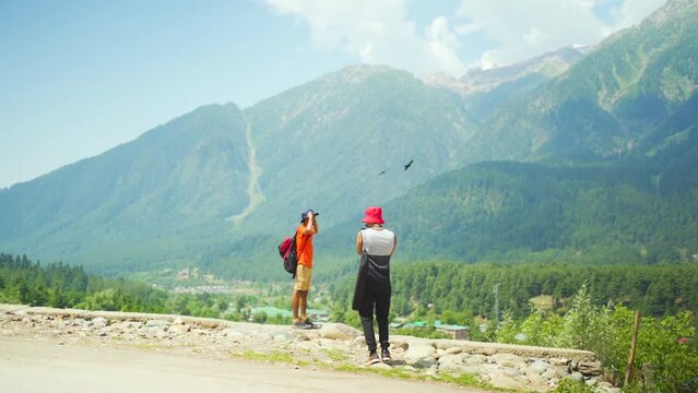 Slow motion of two South Asians taking photos in Gulmarg valley, India