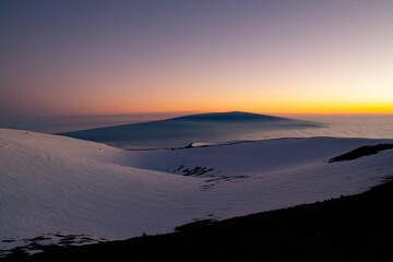 Aerial view of a sunset sky over the snowy Mauna Loa mountains