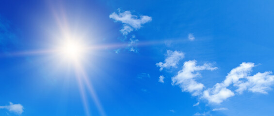 Naklejka na ściany i meble Light clouds and sun in the blue sky. Wide photo.