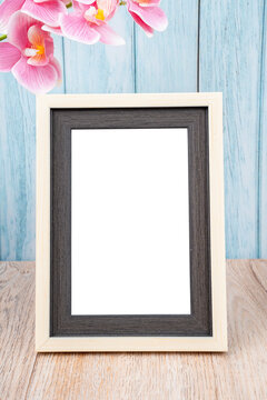 The Blank picture frame and pink orchid on blue wall with copy space and clipping path for the inside.