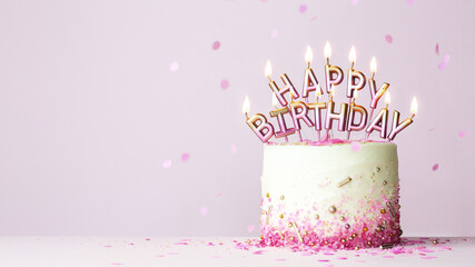 Birthday cake with birthday candles spelling happy birthday