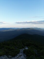 Naklejka premium Vertical shot of mountain fields under a cloudy blue sky