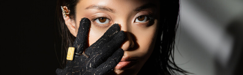 portrait of asian young woman with wet hairstyle and short hair in black glove with golden rings...