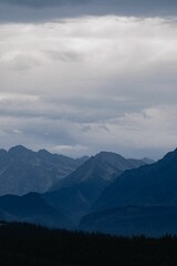 Layers of mountain range in shades of blue, vertical