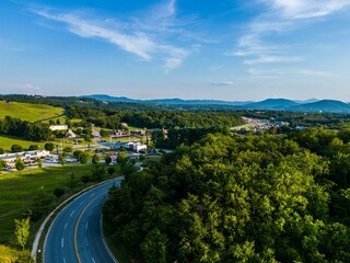 Fototapeta na wymiar Aerial shot of a highway amid the green forests and valleys in Roanoke, VA, USA