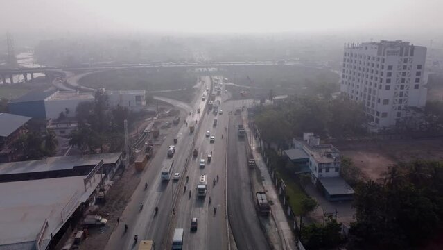 Traffic across the cloverleaf interchange of Maduravoyal flyover Bridge under smoggy and hazy morning sky, Chennai, India