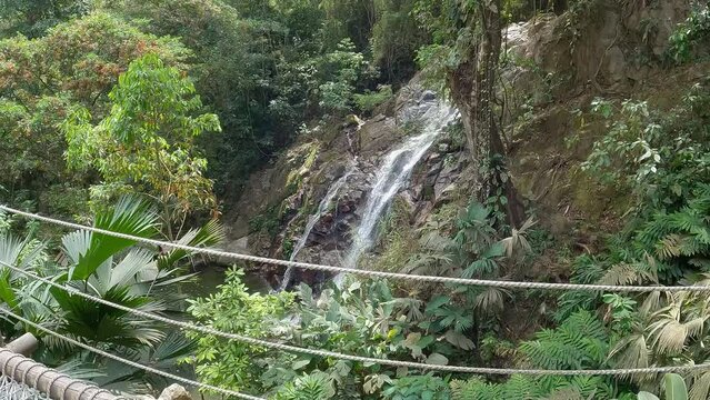 Marinka waterfalls in Minca, Santa Marta Colombia. A nature tourist attraction where people enjoy the refreshing cold water while swimming and bathing below the waterfall in the river.